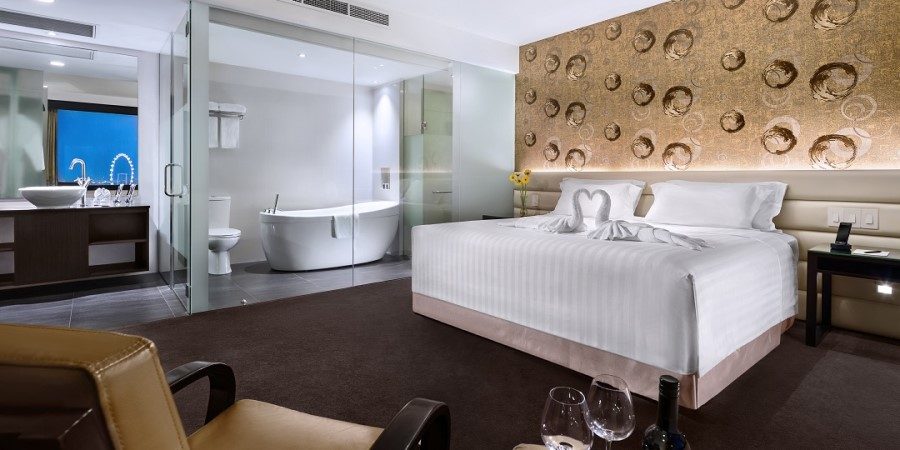 A hotel room featuring a large bed and a freestanding bathtub, creating a cozy and inviting atmosphere.